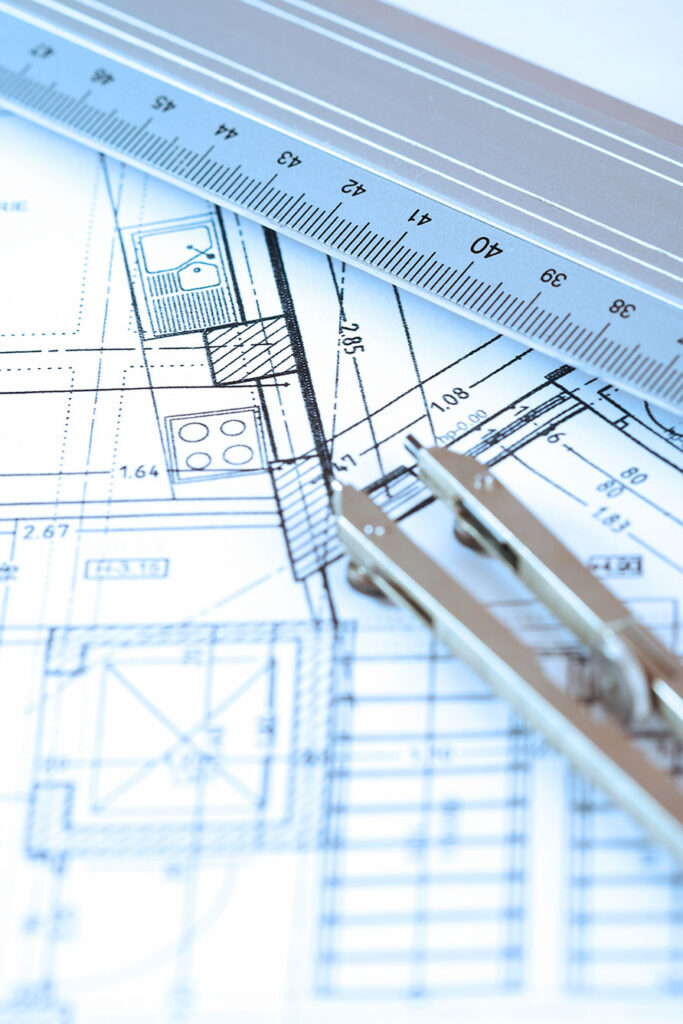 Close up of blueprints, ruler, and protractor.